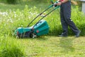 Gardener Mow Grass With Lawn Mower In Garden.