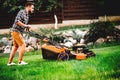 Gardener mowing the lawn using a professional lawnmower