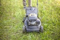 The gardener mows the grass with a lawn mower. Lawn care. Royalty Free Stock Photo