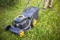 The gardener mows the grass with a lawn mower. Lawn care. Royalty Free Stock Photo