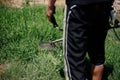 Gardener mows the grass with a trimmer in the yard in the summer Royalty Free Stock Photo