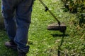 a gardener mows the lawn in his garden plot with a gasoline brush cutter