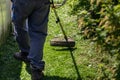 a gardener mows the lawn in his garden plot with a gasoline brush cutter