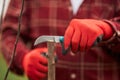 Gardener in plaid shirt cutting tree trunk with knife. Royalty Free Stock Photo