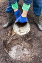 The gardener prepares the ground before planting the bush into the soil. Pouring a hole before planting a berry bush in the garden Royalty Free Stock Photo