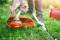 Gardener preparing grass trimmer on lawn in garden outdoors. Royalty Free Stock Photo