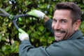 gardener pruning headge with shears