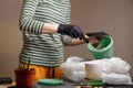 Gardener putting soil into flower pot for planting indoor flowers.