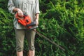 Gardener is ready for trimming overgrown bushes in garden Royalty Free Stock Photo