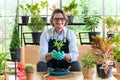 Gardener senior man holding a fresh seedling with soil in hands as a hobby of home gardening at home. new life and environmental Royalty Free Stock Photo