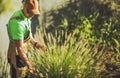 Gardener Taking Care of Decorative Garden Grasses