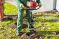 Gardener using tools hand-held soil hole drilling machine or portable manual earth auger Royalty Free Stock Photo