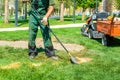 the gardener works with the lawn. sows fresh grass and removes dead grass. shovels and rakes lie in the tractor Royalty Free Stock Photo