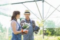 Gardeners discussing over flower pots at greenhouse Royalty Free Stock Photo