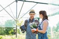 Gardeners discussing over flower pots at greenhouse Royalty Free Stock Photo