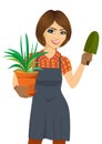 Gardening beautiful woman holding green Chlorophytum plant in the pot and trowel Royalty Free Stock Photo
