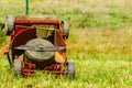 Broken old lawnmower in backyard grass Royalty Free Stock Photo