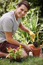 Gardening can be so relaxing. Portrait of a handsome young man gardening outdoors. Royalty Free Stock Photo