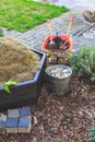 Gardening - composter, bucket with stones and wheelbarrow with soil