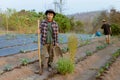 Gardening concept a young farmer shoveling the dirt around the plants to let oxygen get through the roots easily