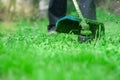 Gardening. Cutting the lawn with cordless grass trimmer, edger
