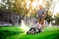 Gardening details, industrial gardener working with lawnmower and cutting grass in backyard