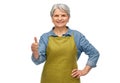 senior woman in garden apron showing thumbs up