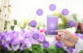 Gardening and flowers e-commerce concept, online shopping on smart phone, hand pointing and touch screen with purple empty icons,