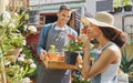 Gardening, flowers and smelling with a black couple working together in a garden or plant nursery as a florist team Royalty Free Stock Photo