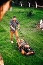 Gardening details, industrial gardener working with lawnmower and cutting grass in garden