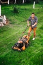 Gardening and landscaping details, industrial gardener working with lawnmower and cutting grass in garden
