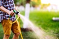 Gardening and maintenance- close up of man hands with hose watering the lawn