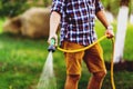 Gardening and maintenance- close up of man with hose watering the lawn