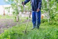 Gardening Maintenance Man Using String Trimmer in Lush Green Environment for Lawn Care and Weed Control Royalty Free Stock Photo