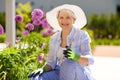 Senior woman with garden pruner and flowers