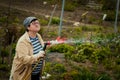 Gardening and people concept - happy senior woman watering lawn by garden hose at summer Royalty Free Stock Photo