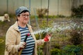 Gardening and people concept - happy senior woman watering lawn by garden hose at summer Royalty Free Stock Photo