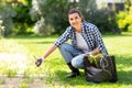 Woman weeding flowerbed at summer garden