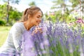 Young woman smelling lavender flowers in garden Royalty Free Stock Photo