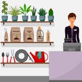 Gardening shop. Flower shop interior. Woman seller behind the counter. Houseplants on shelves, tools for gardening, potting soil,