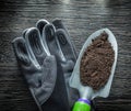 Gardening shovel soil safety gloves on wooden board Royalty Free Stock Photo