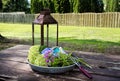 Gardening supplies on picnic table outdoors of home with flowers in tray