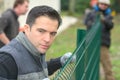 Gardening team putting up garden fence Royalty Free Stock Photo