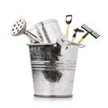 Gardening tools in bucket with watering can isolated