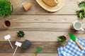 Gardening tools, flowers in pot, grass, and straw hat on vintage wooden background. Spring garden works concept. Flat lay