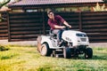Gardening works with man using lawn mower, tractor and industrial tools Royalty Free Stock Photo