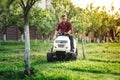 Gardner cutting grass, using professional rideon lawnmower and doing landscaping works