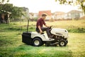 Gardner mowing lawn with ride-on tractor Royalty Free Stock Photo