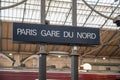 Gare du Nord train station in Paris with a black sign indoors