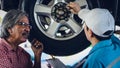 Gargae customer and car mechanic together investigate maintenance and repair programe at garage and car maintenance station Royalty Free Stock Photo